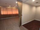 empty room with curtain, wooden floor and recessed lighting