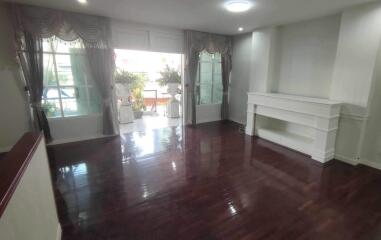 Spacious living room with wooden flooring and natural light