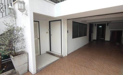 Main entrance of a building with white walls and brown tile flooring