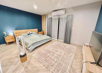 Modern and spacious bedroom with a large bed, air conditioning, and a TV