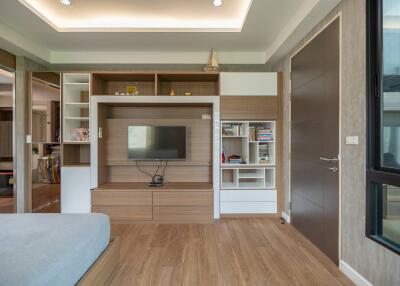 Modern living room with wooden floor, TV unit and bookshelves