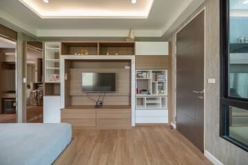 Modern living room with wooden floor, TV unit and bookshelves