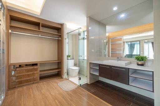 Modern bathroom with spacious layout, wooden floor and glass shower