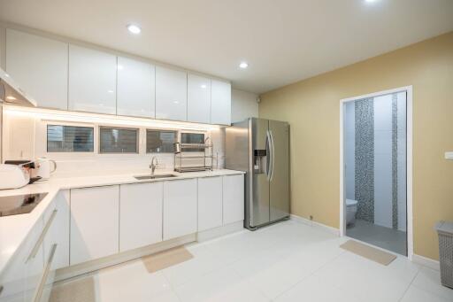 Modern kitchen with white cabinets and large refrigerator