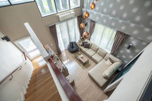 Spacious two-story living room with a modern sectional sofa and large windows