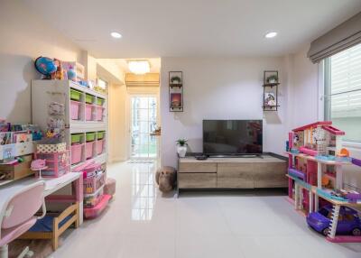 Bright living room with TV, shelving units, children