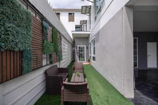 Outdoor seating area with artificial grass and vertical garden