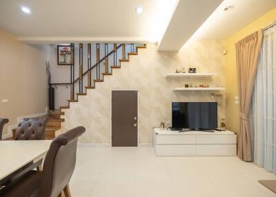 Modern living room with TV and staircase