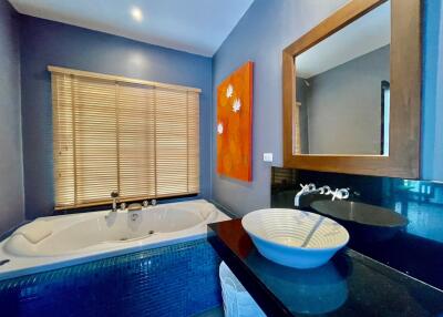 Stylish bathroom with a large jacuzzi tub, modern sink, and bright wall art