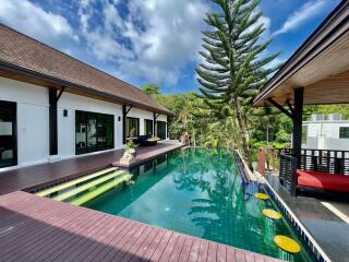 Outdoor swimming pool area with wooden deck and scenic view
