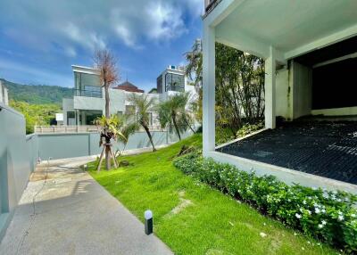 Modern residential building with driveway and landscaped garden