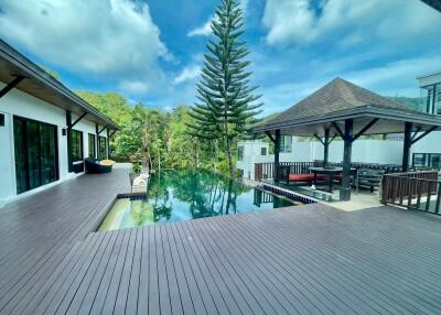 Spacious outdoor deck area with pool and lush greenery