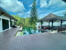 Spacious outdoor deck area with pool and lush greenery