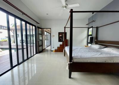 Spacious bedroom with a modern design featuring a large bed and sliding glass doors