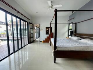 Spacious bedroom with a modern design featuring a large bed and sliding glass doors