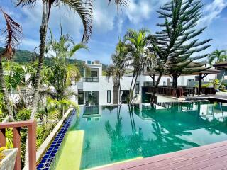 Luxurious outdoor pool surrounded by tropical plants and modern villas