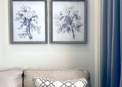 Living room with beige sofa and framed tree artworks