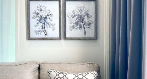 Living room with beige sofa and framed tree artworks