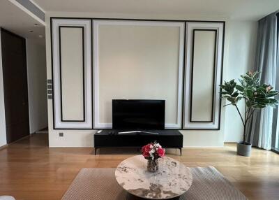 Modern living room with a TV, coffee table, and large window