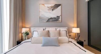 Modern bedroom with art above bed and soft lighting