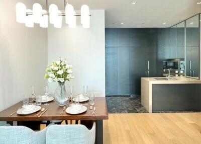 Modern dining room and kitchen area with a set dining table and kitchen appliances