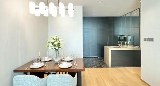 Modern dining room and kitchen area with a set dining table and kitchen appliances