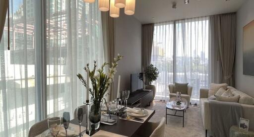 Well-lit modern living room with dining table and large windows