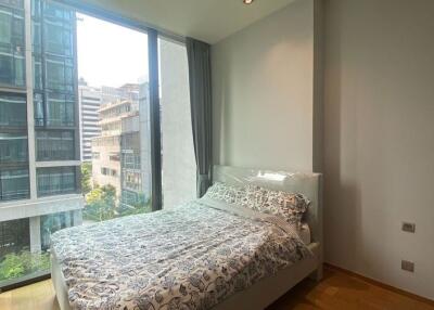 Modern bedroom with large windows and city view