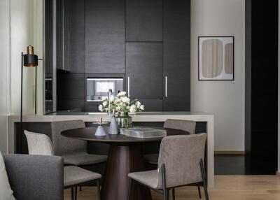 Modern kitchen and dining area with dark cabinets, a round dining table, and contemporary decor.