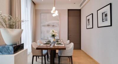 Modern dining room with a rectangular table set for six people, decorated with a central flower arrangement and wall art.