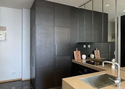 Modern kitchen with dark cabinets, sink, and built-in appliances