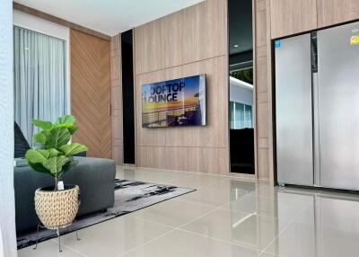 Modern living room with large TV and plant decor