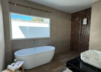 Modern bathroom with a bathtub, shower area, and sink