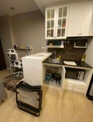 Compact kitchen with white cabinets and a small desk setup