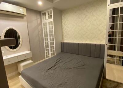Cozy bedroom with a double bed, vanity desk, and air conditioning