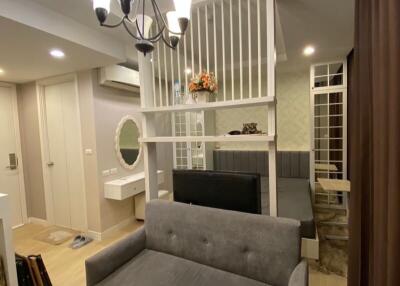 Modern living area with a sofa, chandelier, and partition wall