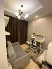 Small bedroom with desk, seating area, and chandelier