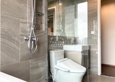 Modern bathroom with glass-enclosed shower, toilet, and vanity with sink