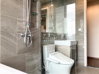 Modern bathroom with glass-enclosed shower, toilet, and vanity with sink