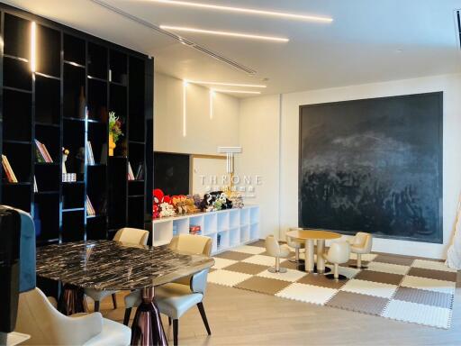 Modern living area with bookshelf, large chalkboard, and seating