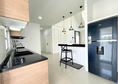 Modern kitchen with black countertops, a breakfast bar, and stainless steel appliances