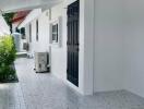 Front view of a modern house with a black door and a tiled walkway