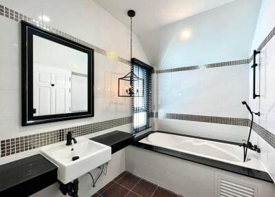 Modern bathroom with bathtub, mirror, and sink