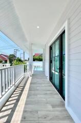 Spacious balcony with wooden flooring and glass doors