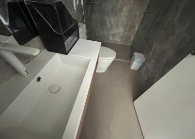 Modern bathroom with a large sink, toilet, and shower area
