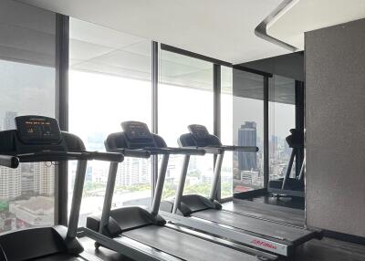 Bright modern fitness room with treadmills and city view