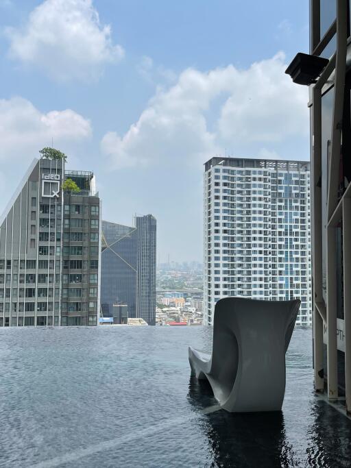 View of infinity pool with cityscape background