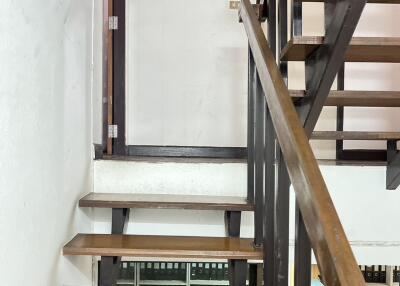 Interior staircase with wooden steps and metal railings