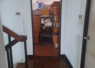 Hallway with staircase and room filled with boxes