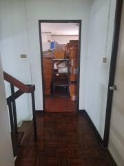 Hallway with staircase and room filled with boxes